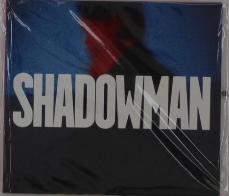 Text: „SHADOWMAN“. Unscharfe Silhouette eines Mannes vor blau-rotem Hintergrund.