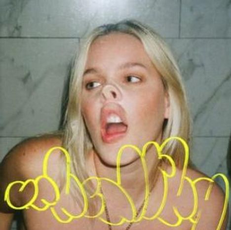 Gelber Text über einer Frau mit blonden Haaren, die ihr Gesicht verzerrt, als hätte sie eine Schweinenase.