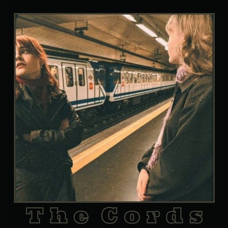 Text "The Cords" unten. Zwei Personen auf einem Bahnsteig, mit U-Bahn im Hintergrund. Retro-Atmosphäre.