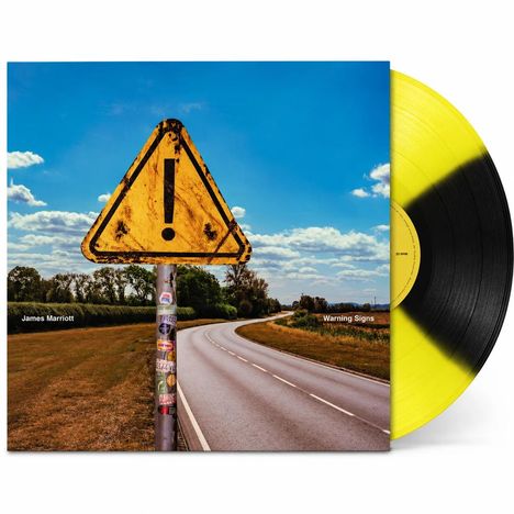 Texte: "James Marriott", "Warning Signs". Gelbes Warnschild mit Ausrufezeichen an einer Landstraße, blauer Himmel.