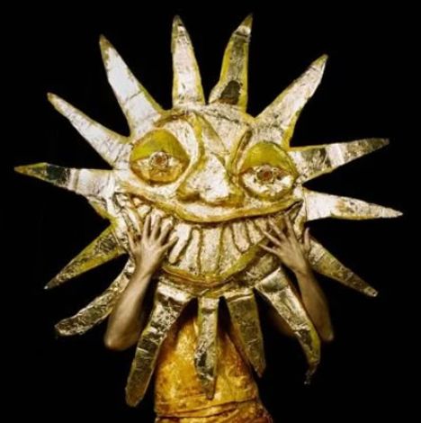 Kein Text vorhanden. Illustration einer großen, lächelnden Sonne aus goldfarbenem Material, die von Händen gehalten wird.