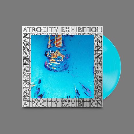 "Atrocity Exhibition" und "Danny Brown" rahmen ein verzerrtes, abstraktes Porträt in Blau. Eine türkisfarbene Vinylplatte.