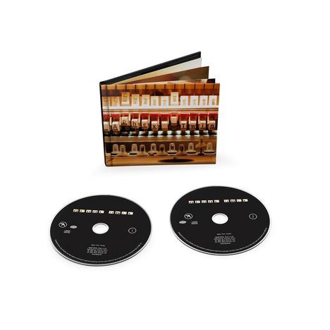 "Aphex Twin" steht auf einem CD-Hüllen Motiv mit Klaviertasten. Zwei schwarze CDs darunter zeigen den gleichen Text.