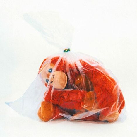 Ein rotes Plüschaffen-Spielzeug ist in eine durchsichtige Plastiktüte verpackt.