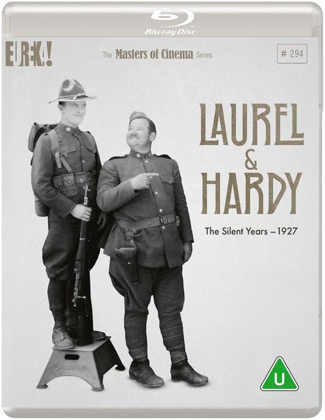"Laurel & Hardy: The Silent Years - 1927." Zwei Männer in Uniformen, einer steht erhöht. Lachender Ausdruck. Vintage-Stil.