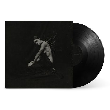 Es gibt keinen sichtbaren Text. Ein Schwarz-Weiß-Cover zeigt eine Person mit nacktem Oberkörper und Flügeln, ein Vinyl liegt rechts.