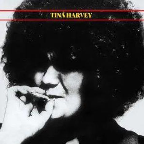 Text: "Tina Harvey". Eine Frau mit lockigem Haar hält die Hand vor den Mund.