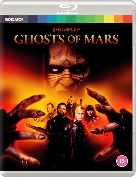 "JOHN CARPENTER'S GHOSTS OF MARS" steht über einem bedrohlichen Gesicht und sechs Personen mit Waffen auf orange-schwarzem Hintergrund.