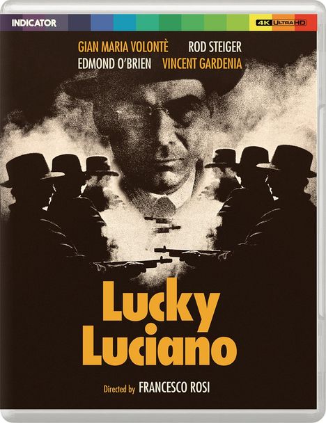 Der Text zeigt Schauspielernamen und Titel: "GIAN MARIA VOLONTÈ, ROD STEIGER, EDWARD O’BRIEN, VINCENT GARDENIA, Lucky Luciano, Directed by FRANCESCO ROSI." Man sieht ein rauchverhangenes Bild eines Mannes mit Hut.