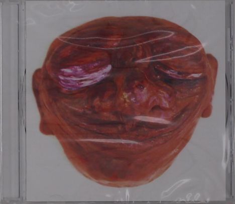 Eine rote, abstrahierte Skulptur eines lächelnden Gesichts mit geschlossenen Augen auf hellem Hintergrund.