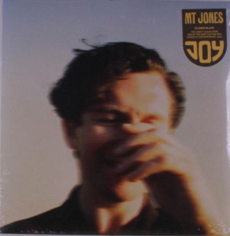 Der Text lautet "MT JONES", "JOY". Unscharfes Foto eines Mannes, der sein Gesicht teilweise bedeckt.