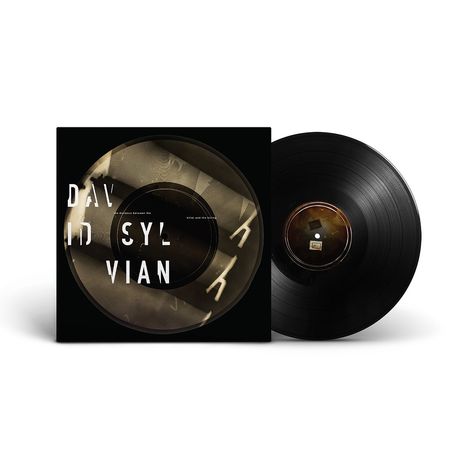 Auf einem Albumcover steht „DAVID SYLVIAN“. Es zeigt eine schwarze Vinyl-Schallplatte und stilisierte grafische Elemente.