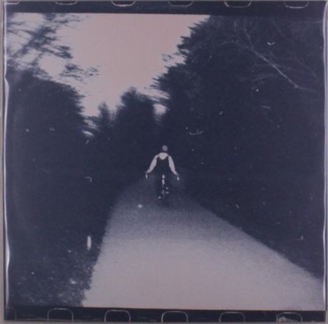 Ich kann keine Texte im Bild erkennen. Es zeigt eine schwarz-weiße Aufnahme von einem Radfahrer auf einem Waldweg.