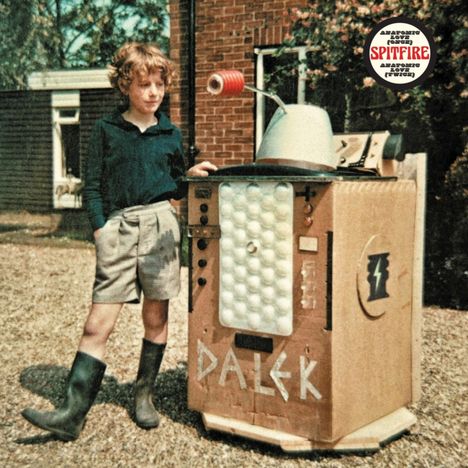 Text: "DALEK", "SPITFIRE". Ein Kind steht neben einer selbstgebauten Roboterkonstruktion aus Pappe mit Knöpfen.