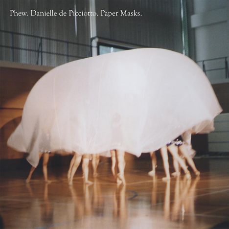 Text: "Phew. Danielle de Picciotto. Paper Masks." Menschen unter großem, lichtdurchlässigem Stoff, der in Turnhalle schwebt.