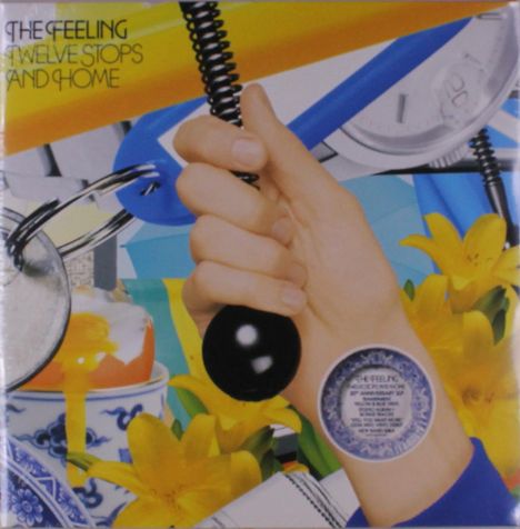 "The Feeling, Twelve Stops and Home" steht oben links. Eine Hand hält einen schwarzen Griff; im Hintergrund gelbe Blumen.