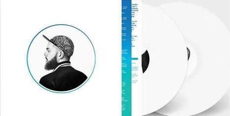 Eine Vinylhülle mit einem Foto eines bärtigen Mannes im Profil, der eine bedruckte Kappe trägt; daneben eine weiße Schallplatte.