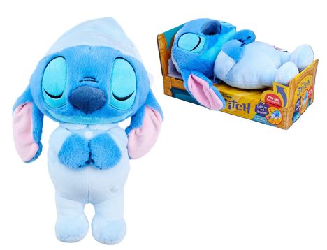 "Try Me" und "Stitch" sind sichtbar. Ein blaues Plüschtier mit geschlossenen Augen trägt Schlafkleidung und liegt in einer bunten Verpackung.