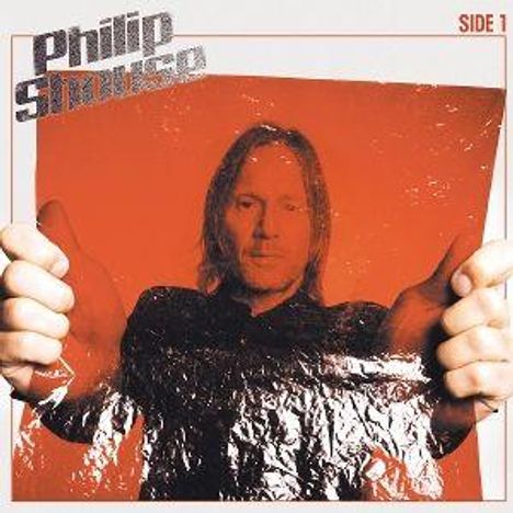 "Philip Shauseo" und "Side 1" stehen oben. Eine Person hält eine reflektierende Folie vor einem orangenen Hintergrund.