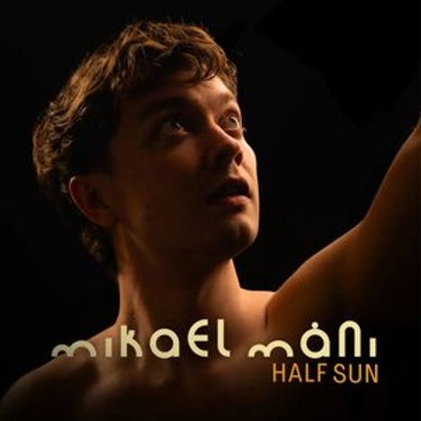 Text: "mikael máni HALF SUN". Ein Mann schaut nach oben, beleuchtet mit warmem Licht.