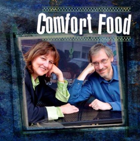 "Comfort Food" steht oben. Zwei Personen lehnen sich an einen Tisch und lächeln freundlich.