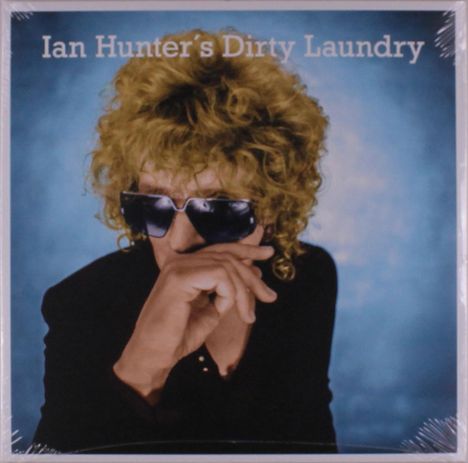 „Ian Hunter’s Dirty Laundry“; Person mit lockigem Haar und Sonnenbrille, blauem Hintergrund.
