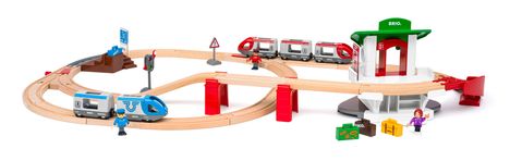 Eine Spielzeugeisenbahn auf Holzschienen mit blau-grauen und rot-grauen Zügen, einer Brücke und Personenfiguren.
