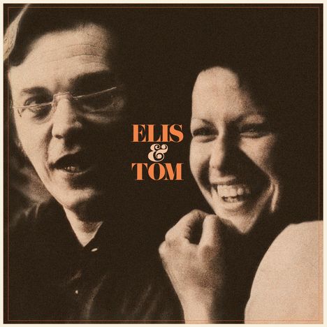 "ELIS & TOM". Zwei Personen lächeln, eine trägt eine Brille. Porträt in nostalgischen Farben.