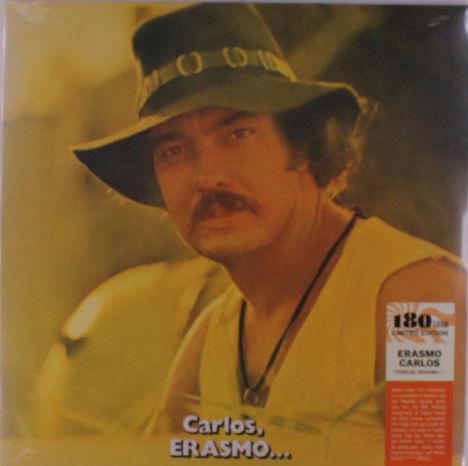 „Carlos, ERASMO…“ Ein Mann mit Hut und Bart blickt ernst, trägt ein ärmelloses Oberteil. Im Hintergrund unscharf.