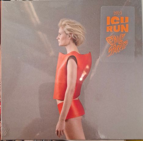 2025 ICU RUN. Eine Person in einem roten Outfit, seitlich stehend, auf grauem Hintergrund.