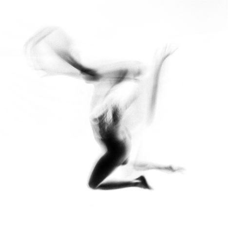 Keine Texte erkennbar. Verschwommene Darstellung einer dynamisch bewegten Person in Schwarz-Weiß.