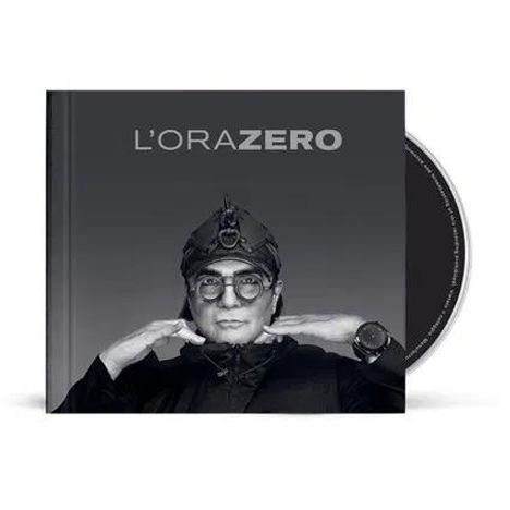 L'ORA ZERO. Ein Mann mit Brille und Helm hebt die Hände, vor einem grauen Hintergrund. Eine CD-Hülle ist sichtbar.