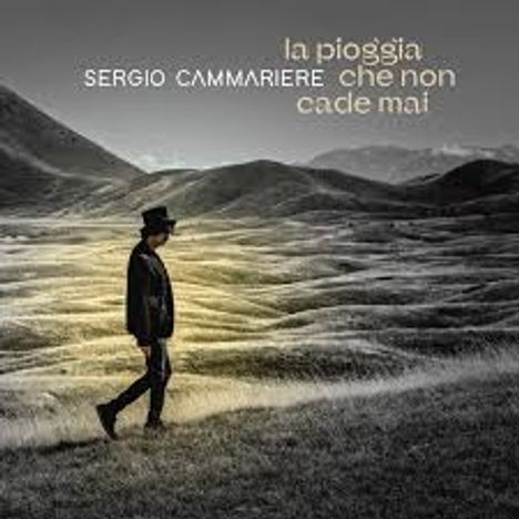La pioggia che non cade mai, Sergio Cammariere. Mensch mit Hut geht durch eine bergige, wolkenverhangene Landschaft.