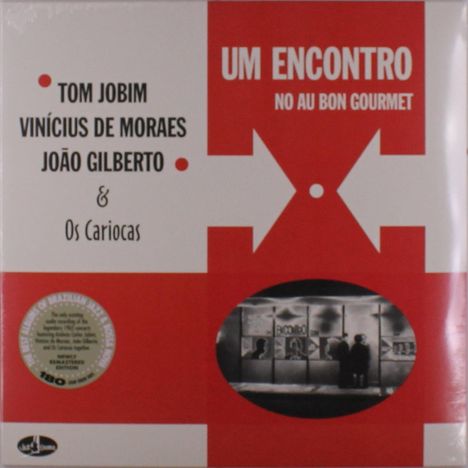 Texte: "UM ENCONTRO NO AU BON GOURMET", "TOM JOBIM", "VINÍCIUS DE MORAES", "JOÃO GILBERTO", "& Os Cariocas".   
Grafik: Pfeile und ein ovales Foto mit Personen.