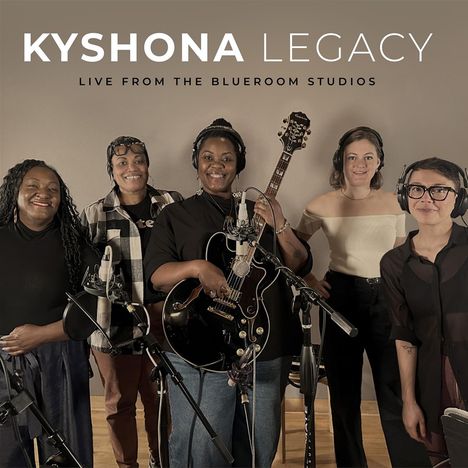"KYSHONA LEGACY" "LIVE FROM THE BLUEROOM STUDIOS". Fünf Personen mit Instrumenten und Mikrofonen lächeln in die Kamera.