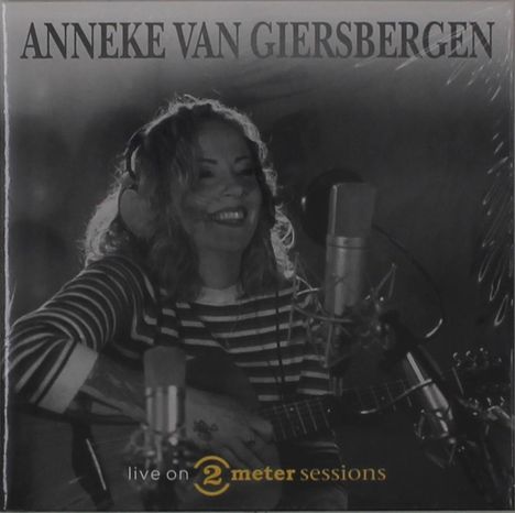"Oberhalb: ANNEKE VAN GIERSBERGEN; Unten: live on 2 meter sessions. Frau mit Kopfhörern und Gitarre vor Mikrophon."