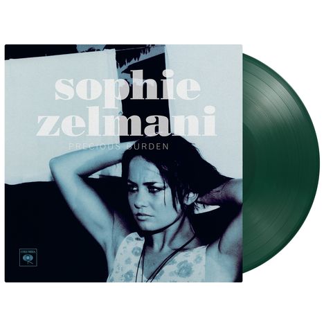 "sophie zelmani, PRECIOUS BURDEN". Schwarz-weiße Fotografie einer nachdenklichen Frau mit Händen hinter dem Kopf.