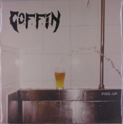 Der Text "COFFIN" und "PISS-UP" ist zu sehen. Ein Glas mit gelbem Getränk steht auf einem metallischen Waschbecken.