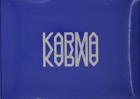 Weiße, geometrische Schrift "KARMA" auf blauem Hintergrund. Symmetrisch und stilisiert, mit einem modernen Eindruck.