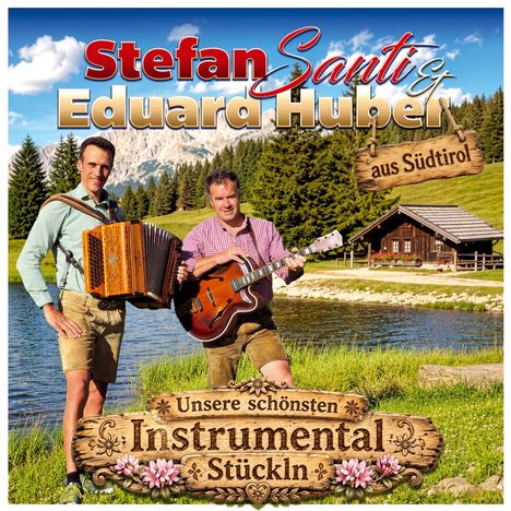 Stefan Santi und Eduard Huber, aus Südtirol. Zwei Männer in Lederhosen mit Instrumenten vor Alm-See und Hütte.