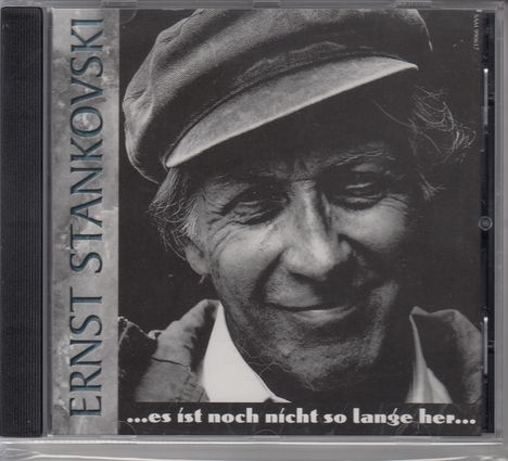 "ERNST STANKOVSKI" steht links vertikal. Unten: "...es ist noch nicht so lange her...". Schwarz-weißes Foto eines lächelnden Mannes mit Mütze.