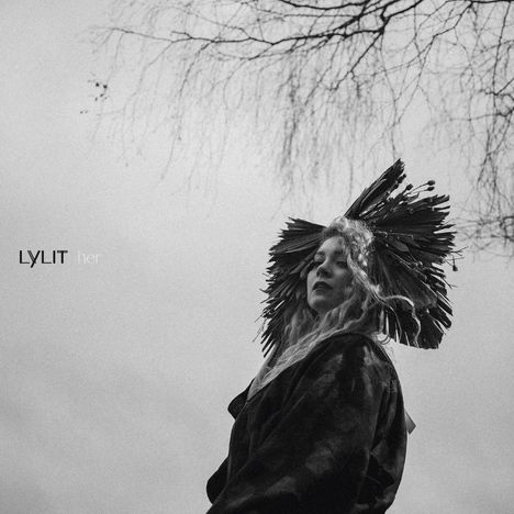 Text: "LYLIT her". Eine Frau mit Krone aus Ästen schaut ernst in die Ferne, kahler Baum im Hintergrund.