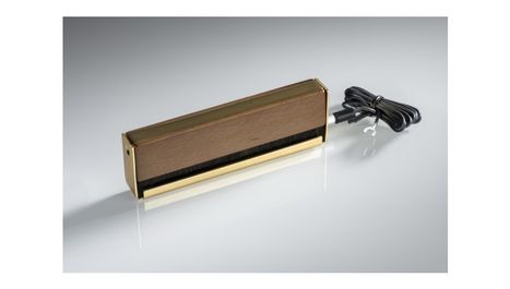 Ich kann leider den Text nicht entziffern. Das Bild zeigt eine rechteckige Holzbox mit goldenen Akzenten und einem Kabel.