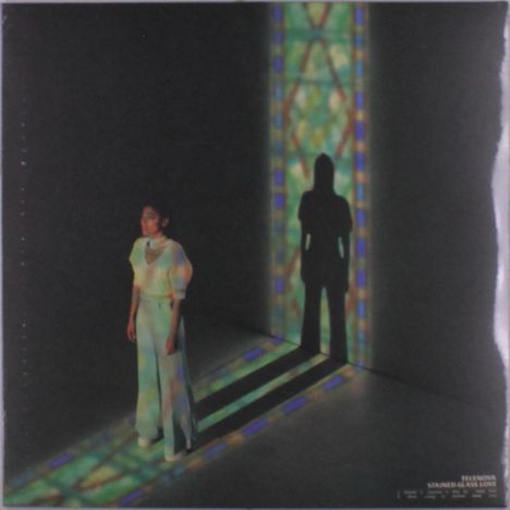 "Tele Novella Stained Glass Love". Frau steht im Licht eines bunten Fensters, ihr Schatten auf der Wand.