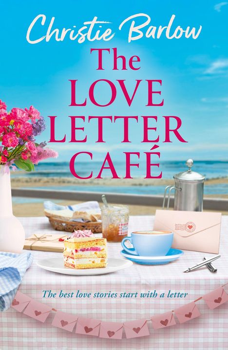 „The LOVE LETTER CAFÉ“, „The best love stories start with a letter“. Ein Tisch am Strand mit Kaffee, Kuchen und Blumen.