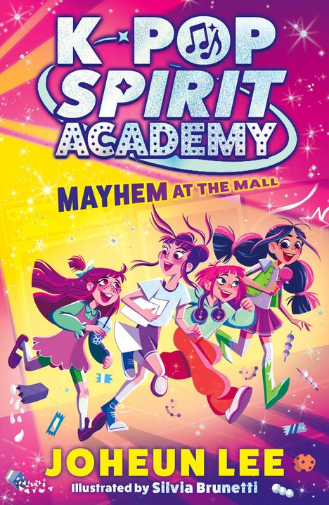 „K-POP SPIRIT ACADEMY: MAYHEM AT THE MALL“ ist in bunten, glitzernden Buchstaben zu sehen. Vier fröhliche Mädchen laufen dynamisch.