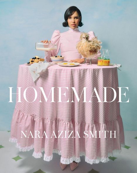 Texte: HOMEMADE, NARA AZIZA SMITH. Eine Frau mit Vintage-Kleid steht hinter einem gedeckten Tisch.