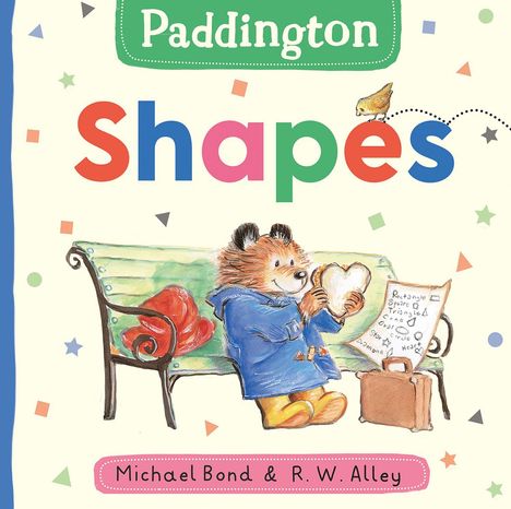 "Paddington Shapes" ist der Titel. Ein Bär in blauem Mantel hält ein herzförmiges Sandwich auf einer Bank.