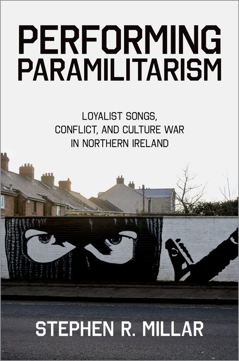 "PERFORMING PARAMILITARISM" zeigt Häuser und ein Wandgemälde mit Augen und einer vermummten Person.