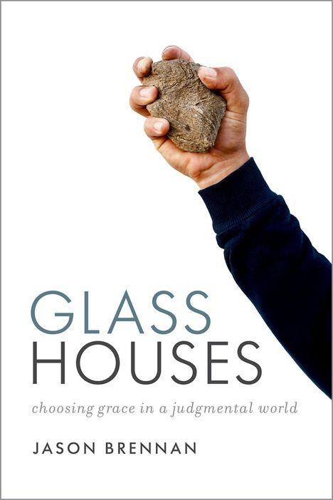 "GLASS HOUSES", darunter "choosing grace in a judgmental world". Eine Hand hält einen Stein, vor einem weißen Hintergrund.